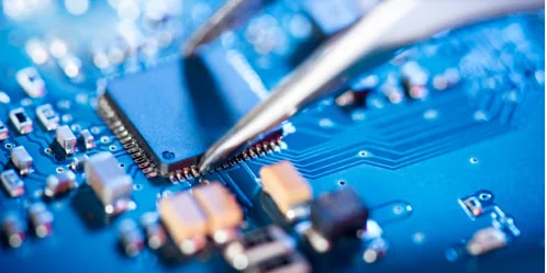 青い基板上の半導体チップとピンセット