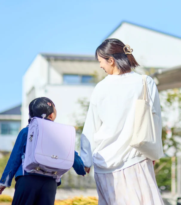 手をつないで歩く親子の後ろ姿