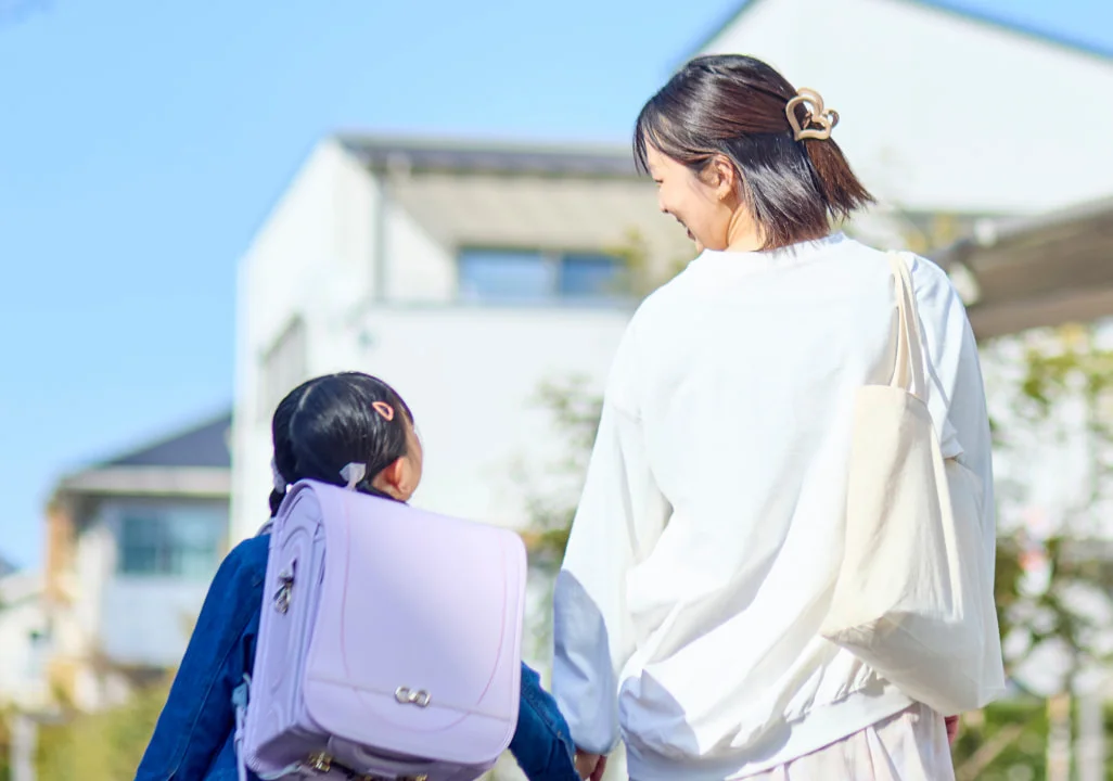 手をつないで歩く親子の後ろ姿