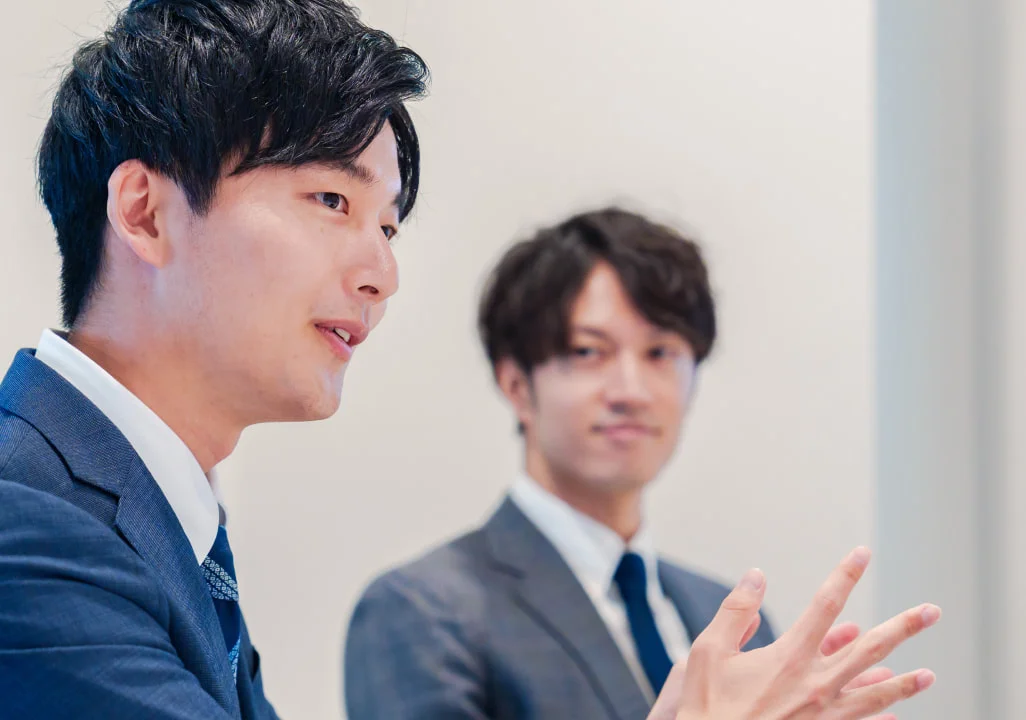 スーツ姿で話し合う2人の社員