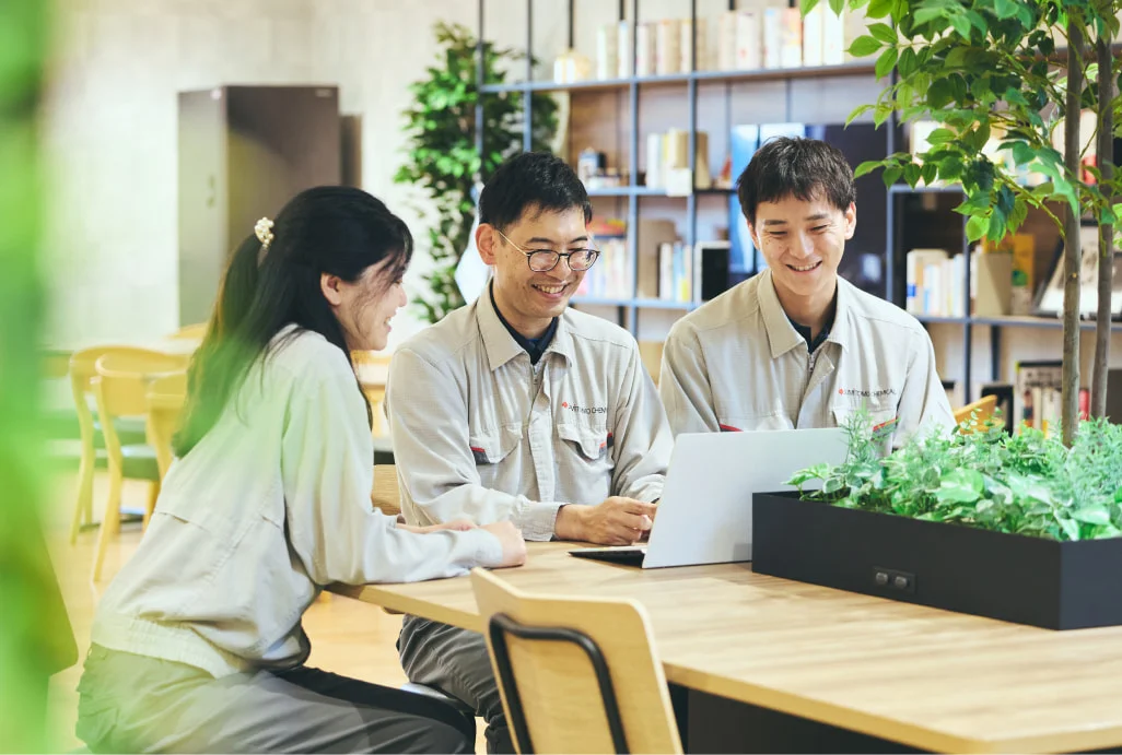 作業着姿でノートPCを囲む3人の社員