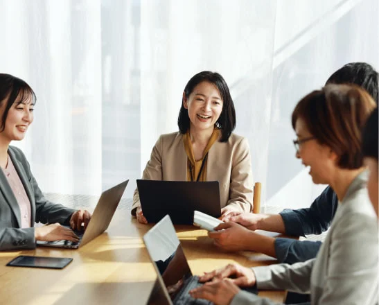 ノートPCを囲んで会議する社員たち