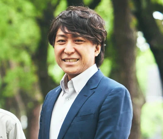 スーツ姿で微笑むY. T.