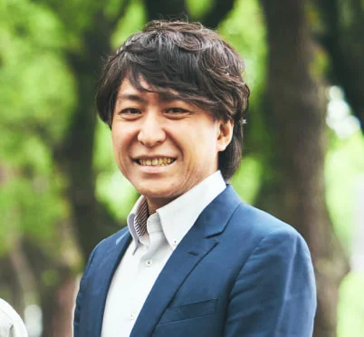 スーツ姿で微笑むY. T.