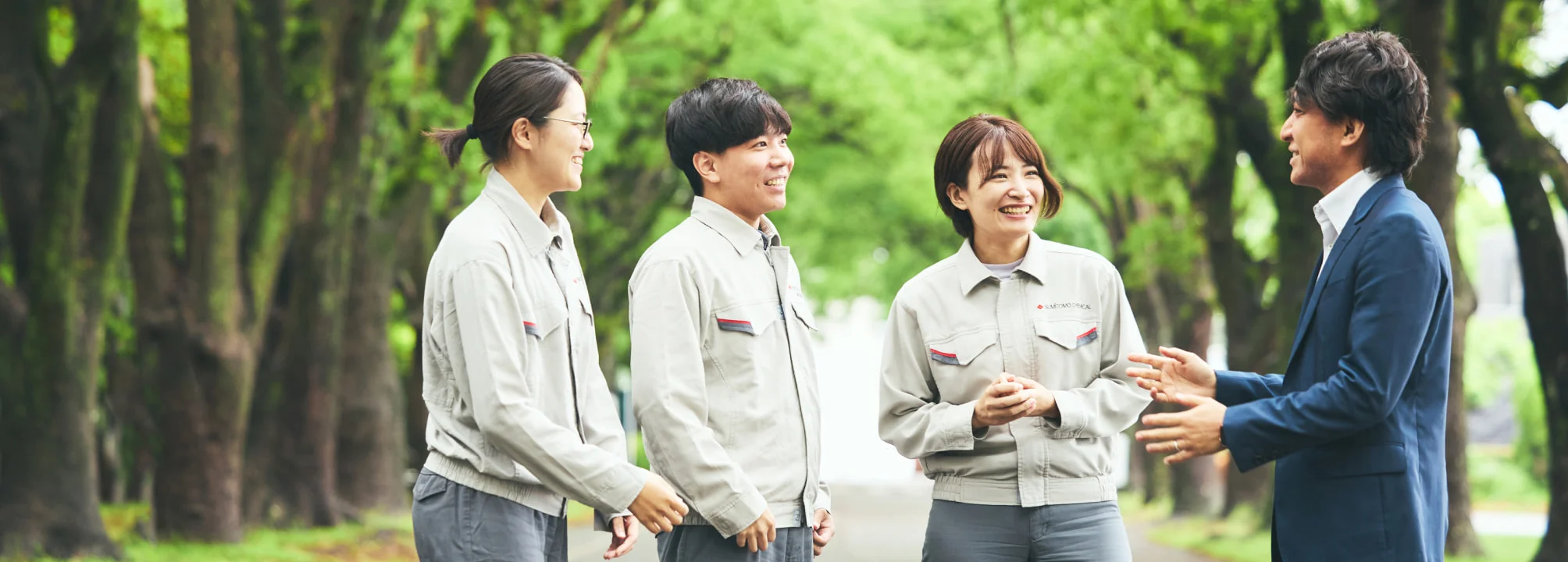 並木道で4人が向き合い話す様子