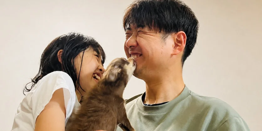 愛犬とじゃれ合うK. M.と子ども