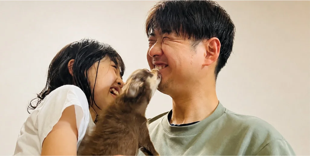 愛犬とじゃれ合うK. M.と子ども