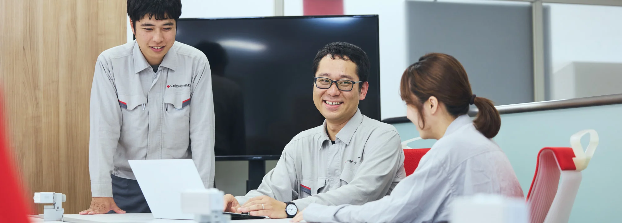 同僚とノートPCを囲んで笑うN. K.