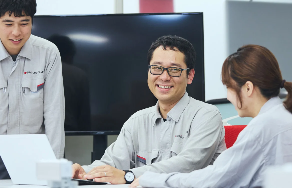同僚とノートPCを囲んで笑うN. K.