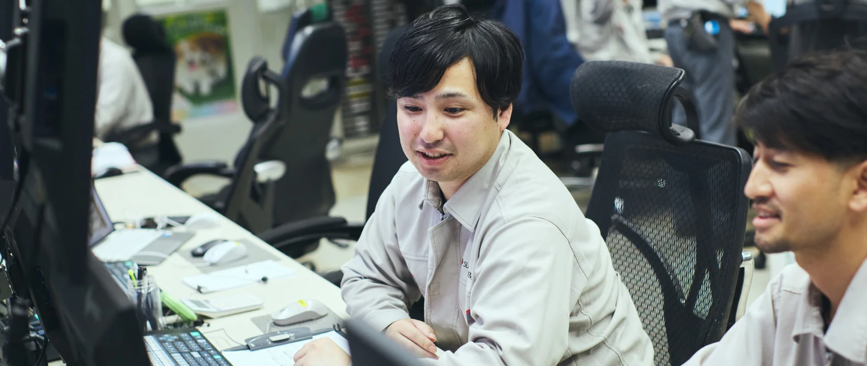 オフィスで同僚と話すN. Y.