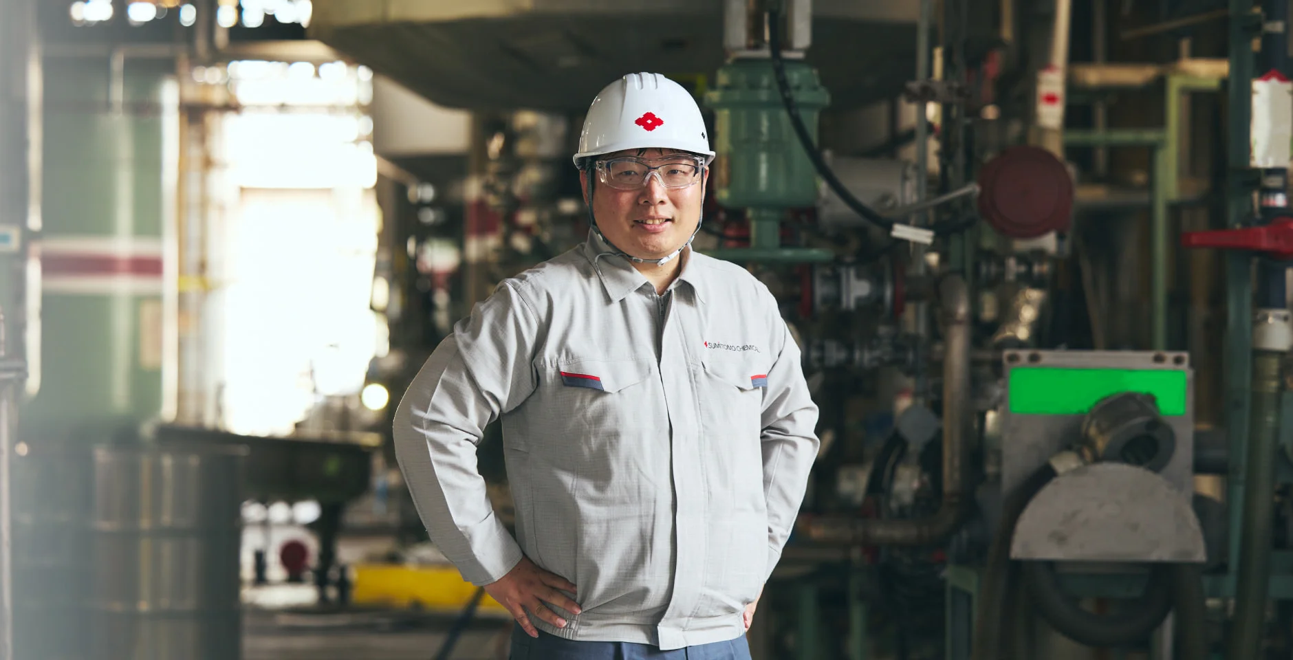 ヘルメット姿でプラントに立つM. T.