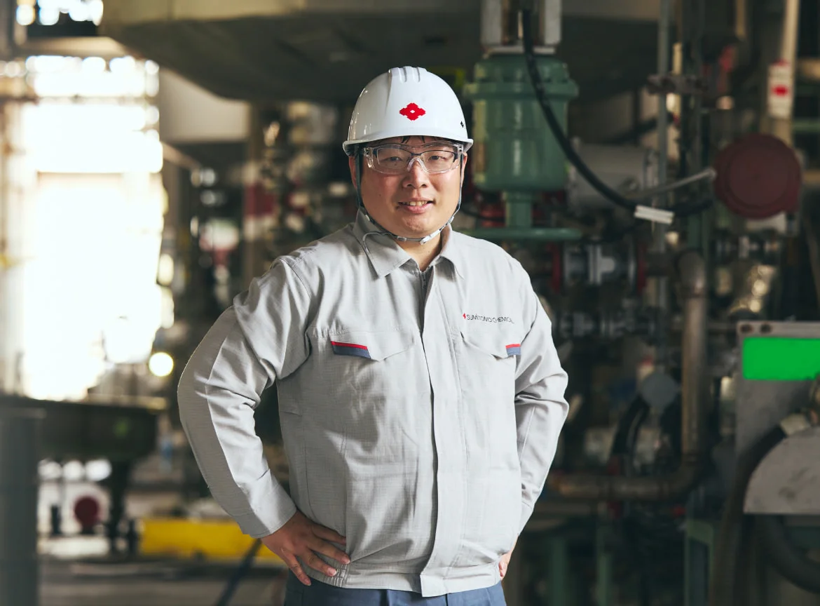 ヘルメット姿でプラントに立つM. T.