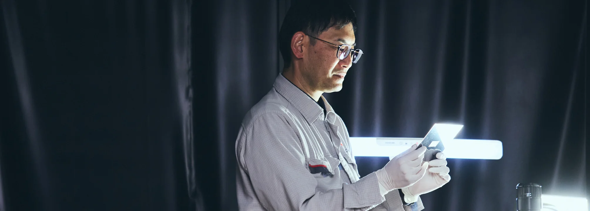 電池部材を光にかざして検査するO. T.
