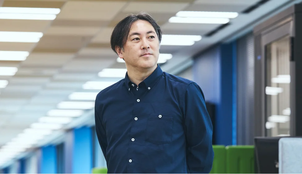 オフィスの通路で視線を上げるS. T.